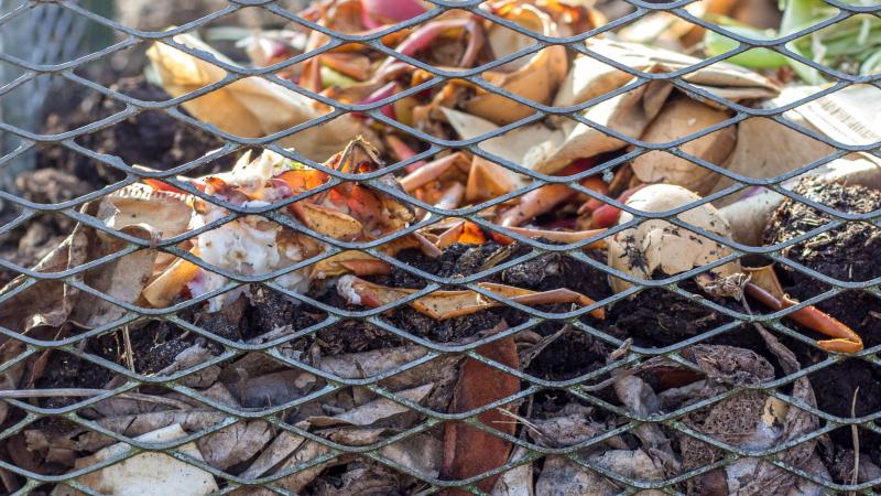 Enkele houten palen, wat tuingaas en een goede mix tussen groene en bruine materialen vormen de basis voor een goed composteringsproces.