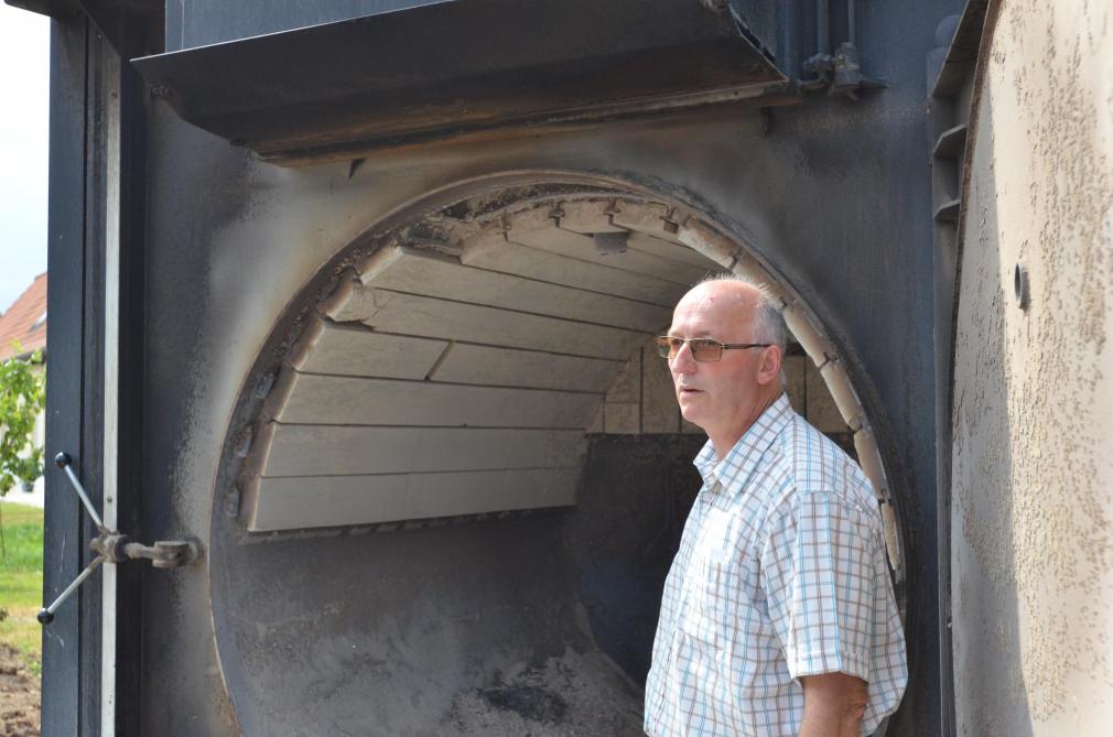 Jean-Bernard Ronckier voor de verwarmingsketel die op biomassa draait.