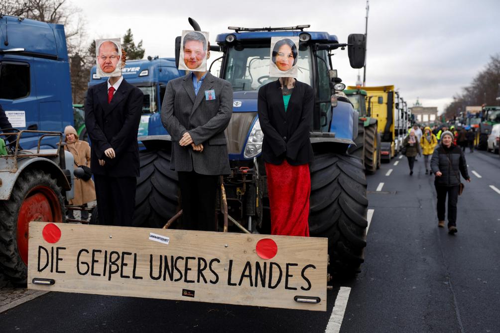 Een tractor met poppen van Duitse kanselier Olaf Scholz, minister van Economie en Klimaatbescherming Robert Habeck en minister van Buitenlandse Zaken Annalena Baerbock. Hun regering wil af van bepaalde belastingvoordelen, zoals het gunstige belastingregime voor diesel voor landbouwvoertuigen.