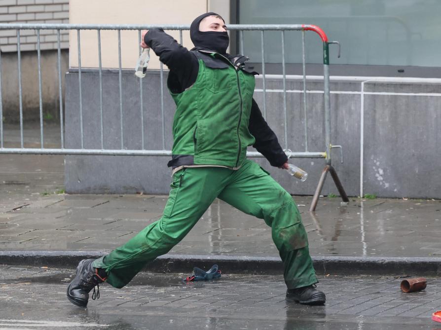 Actievoerders gooien tijdens het protest bommetjes, klein vuurwerk en andere projectielen.