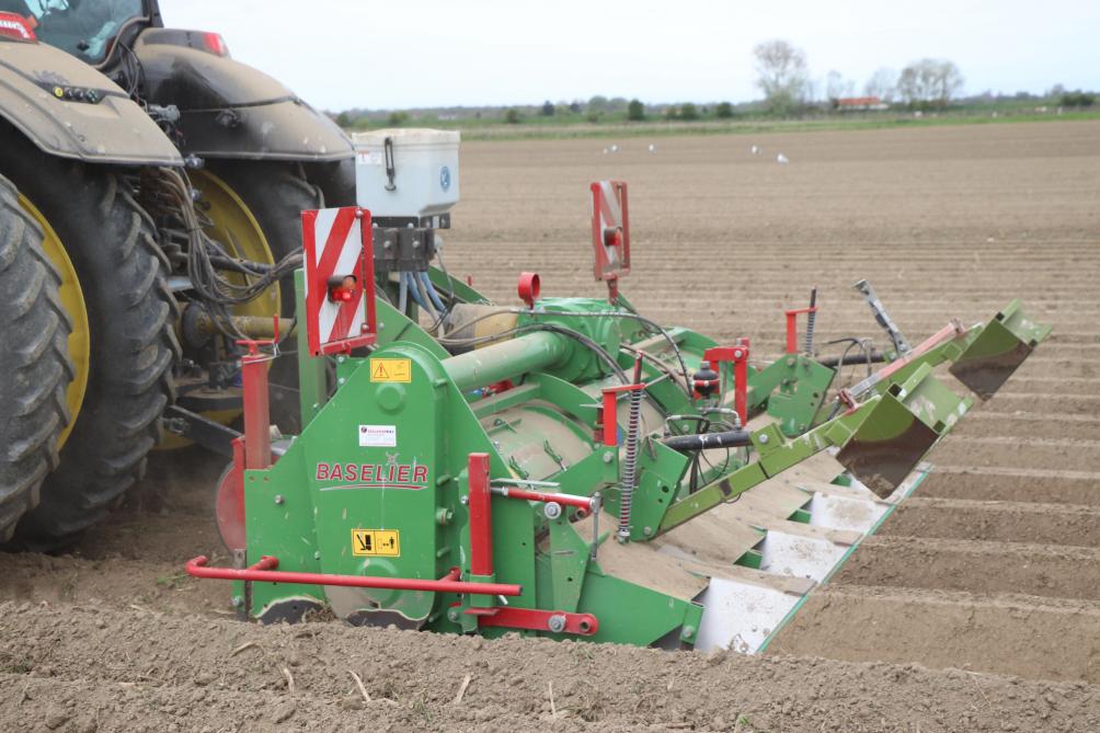 Een vennoot van Michael is bezig de aardappelruggen te maken. In de hef hangt een Baselier FK 4-rijige rijenfrees, met daarop een Gandy-rijenstrooier om slakkenkorrels toe te voegen.