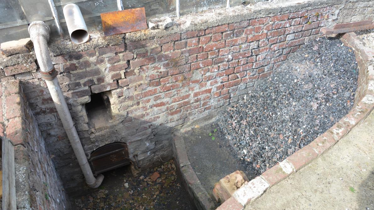Het verwarmen van de serres gebeurt vaak met steenkool (zie rechts op de foto), wat handenvol geld kost.