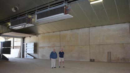 Jan en Josse Peeters in hun bewaarloods met bovenaan twee van de vier  mechanische koelelementen.