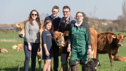 Omringd door hun drie kinderen, poseren Bernard en Delphine voor een deel van hun veertigtal Jerseykoeien. Een ras dat hen volledige voldoening schenkt.