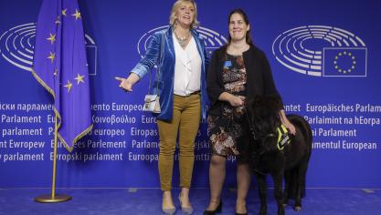 Hilde Vautmans (links) vorig jaar in het Europees Parlement, met blindengeleidepaard Dinky en diens eigenaar.