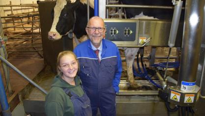 Luk Lemmens, gedeputeerde voor Onderwijs in Antwerpen, en Klaartje Kenis, melkster op PITO Stabroek, poseren trots voor de nieuwe melkrobot.