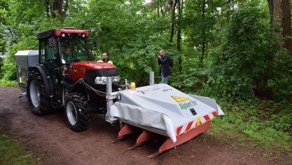 Zicht op de machine met de applicators/glijsloffen/lamellen die de elektrische stroom afgeeft op de ongewenste plantengroei. (opgevouwen veiligheidsvoorziening omwille van de foto) Achteraan de tractor hangt de generator voor de elektriciteitsopwekking.