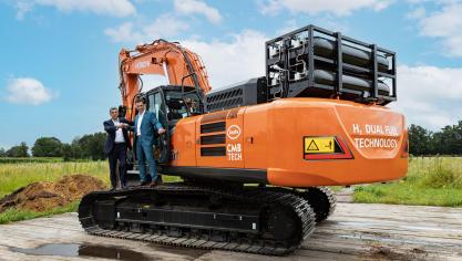 Jos Luyckx - CEO Luyckx (l) en Roy Campe - CTO CBM.TECH (r) bij de Hitachi graafmachine die zij voorzagen van de dual fuel technologie waarbij de dieselmotor een deel waterstof bij mengt.