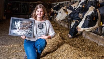 Ilse Louwagie met de winnende foto inde stal waar ze deze foto nam.