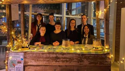 Allyssa ‘t Kindt, Judit Vancoppenolle, Febe Decadt, Hanne Boone, Justine Ghesquière, Guillaume Delefortrie en Siriyakorn Klaklang stellen trots hun kaartspel voor op de aandeelhoudersvergadering.