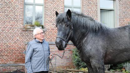 Cyr met zijn hengst Uniek van de Zaaidijk op de binnenkoer van de hoeve te Maarkedal in december 2022.