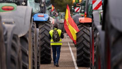 Een Spaanse boer houdt de Spaanse vlag vast tijdens een protest op 15 maart. Het pakket aan maatregelen van de Spaanse landbouwminister moet een antwoord bieden aan de eisen van deze boeren.