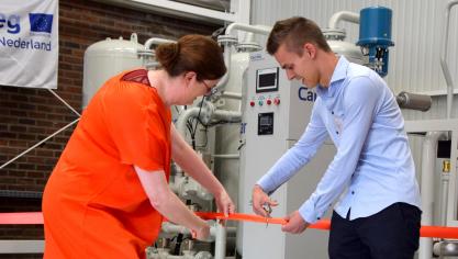 Sofie Mols, directeur innovatie en internationalisering van Thomas More, en tuinder Mitch Vermeiren, voorzitter van de Kempische Glasgroentenkring, knippen het lint bij de opening van de CO 2 -zuiveringsinstallatie.