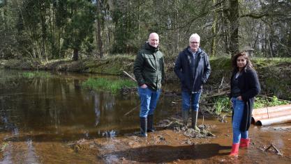 V.l.n.r. getroffen landbouwer Ben Van Looveren, gedeputeerde De Haes en gedeputeerde Beels bij een veld dat onder water komt te staan door een beverdam.