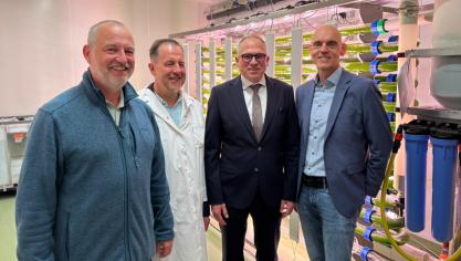 Professor Wim Vanden Berghe (UAntwerpen), Johan Robbens (ILVO), minister-president Matthias Diependaele en professor Leo van Grunsven (VUB) voor de 300 l algenreactor bij ILVO in Oostende.