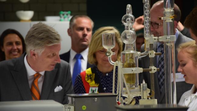Een leerling van de schoolhoeve in Torhout legt koning Filip en onderwijsminister Hilde Crevits een chemische proef uit.
