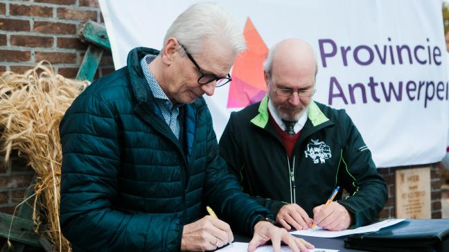 Gedeputeerde Jan De Haes (links) en voorzitter Jan Martens van de Stichting Levend Erfgoed ondertekenen het charter.