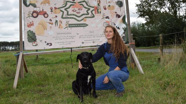 Janne met trouwe hond Storm voor het welkomstpaneel aan de ingang van  de maïsdoolhof.