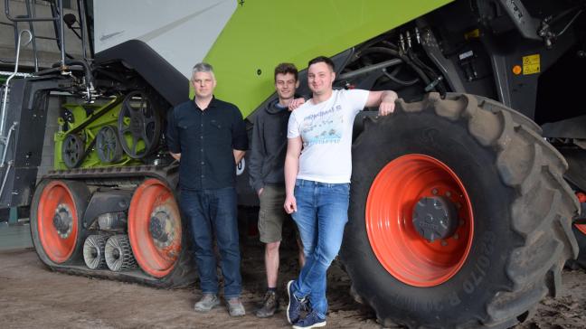 Docent Kris Michiels, Alexander Hoes en Pieter Reynebeau (v.l.n.r.) bij de indrukwekkende Claas-hakselaar.