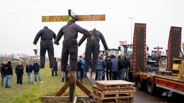 De 3 poppen in overals staan voor boeren die de das omgedaan worden door de partijen N-VA, Open VLD en cd&v.