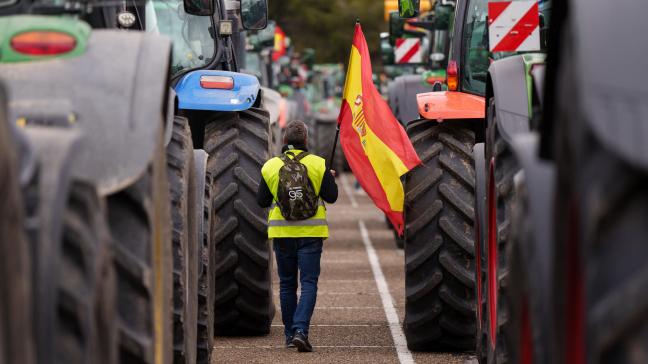 Een Spaanse boer houdt de Spaanse vlag vast tijdens een protest op 15 maart. Het pakket aan maatregelen van de Spaanse landbouwminister moet een antwoord bieden aan de eisen van deze boeren.