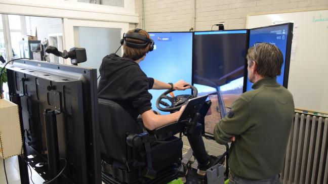 Joshua oefent onder het toeziend oog van technisch adviseur Xavier Geerolf een realistische landbouwsituatie: graan vervoeren van een oogstmachine naar een silo.