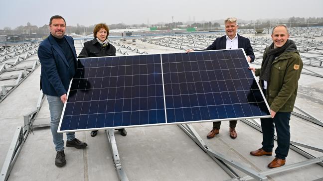 Plaatsing van het eerste zonnepaneel op het dak van de Milcobel-vestiging in Brugge. V.l.n.r. Pablo Annys, schepen van energie van Brugge, Greet de Gueldre, vice-president Ecopower, Peter Grugeon, CEO Milcobel en Frédéric Haghebaert, algemeen directeur Beauvent.