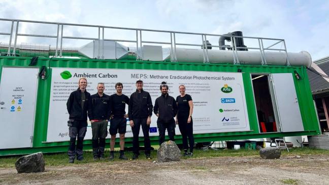 Een deel van het onderzoeksteam van Ambient Carbon bij de container met de installatie op de testlocatie.