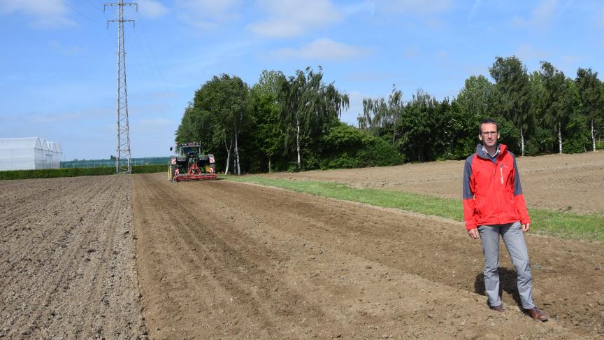 Lieven Delanote met op de  achtergrond de breedspoortractor voor de vaste rijpaden.