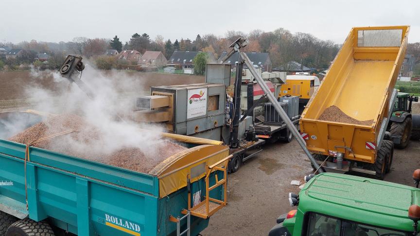 Van de kipper (rechtsboven in beeld) gaan de veldbonen naar de mobiele toaster (centraal). De verhitte bonen komen terug in een andere kipper terecht of rechtstreeks op een verharde vloer voor afkoeling.