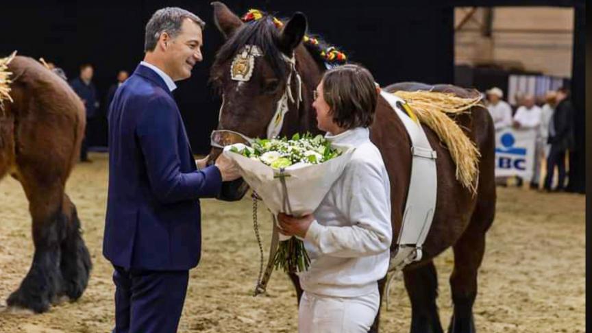 Premier Alexander De Croo overhandigt de bloemen aan Elien Vandecasteele van Stal van de Zoetemond voor de merrie met kweek Rika du Blanc Bois.
