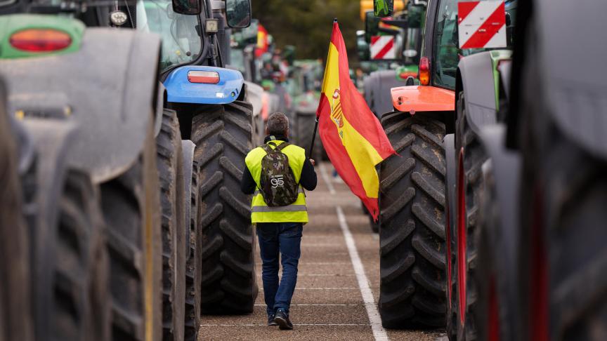 Een Spaanse boer houdt de Spaanse vlag vast tijdens een protest op 15 maart. Het pakket aan maatregelen van de Spaanse landbouwminister moet een antwoord bieden aan de eisen van deze boeren.