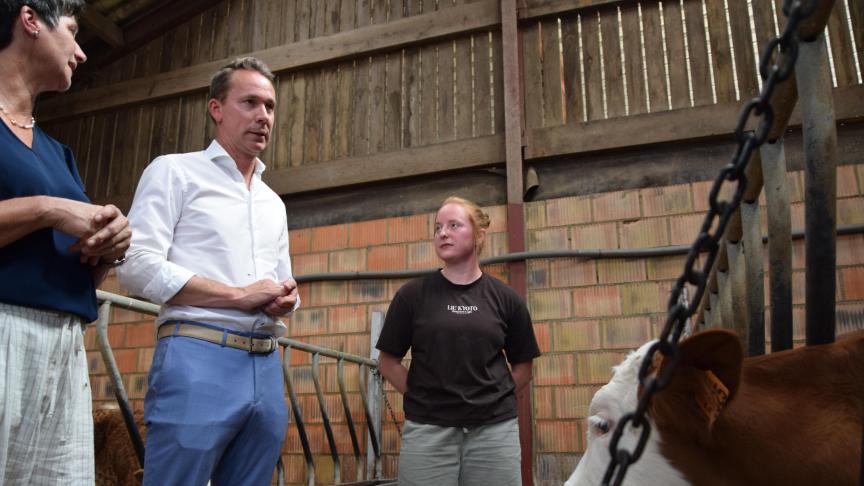 Melkveehouder Annick Strauven en haar zorggast Stephanie leiden minister Jo Brouns rond tijdens een bezoek aan de zorgboerderij op 27 augustus.