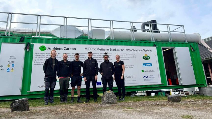 Een deel van het onderzoeksteam van Ambient Carbon bij de container met de installatie op de testlocatie.