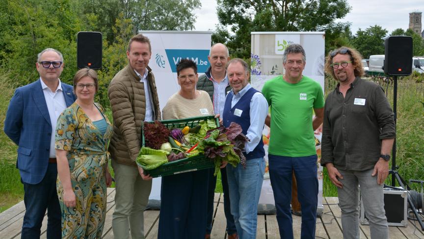 Vlaams minister van Landbouw Jo Brouns en CEO van VLAM Filip Fontaine (centraal op de foto) trapten de Bioweek af bij bioboerderij Den Diepen Boomgaard.
